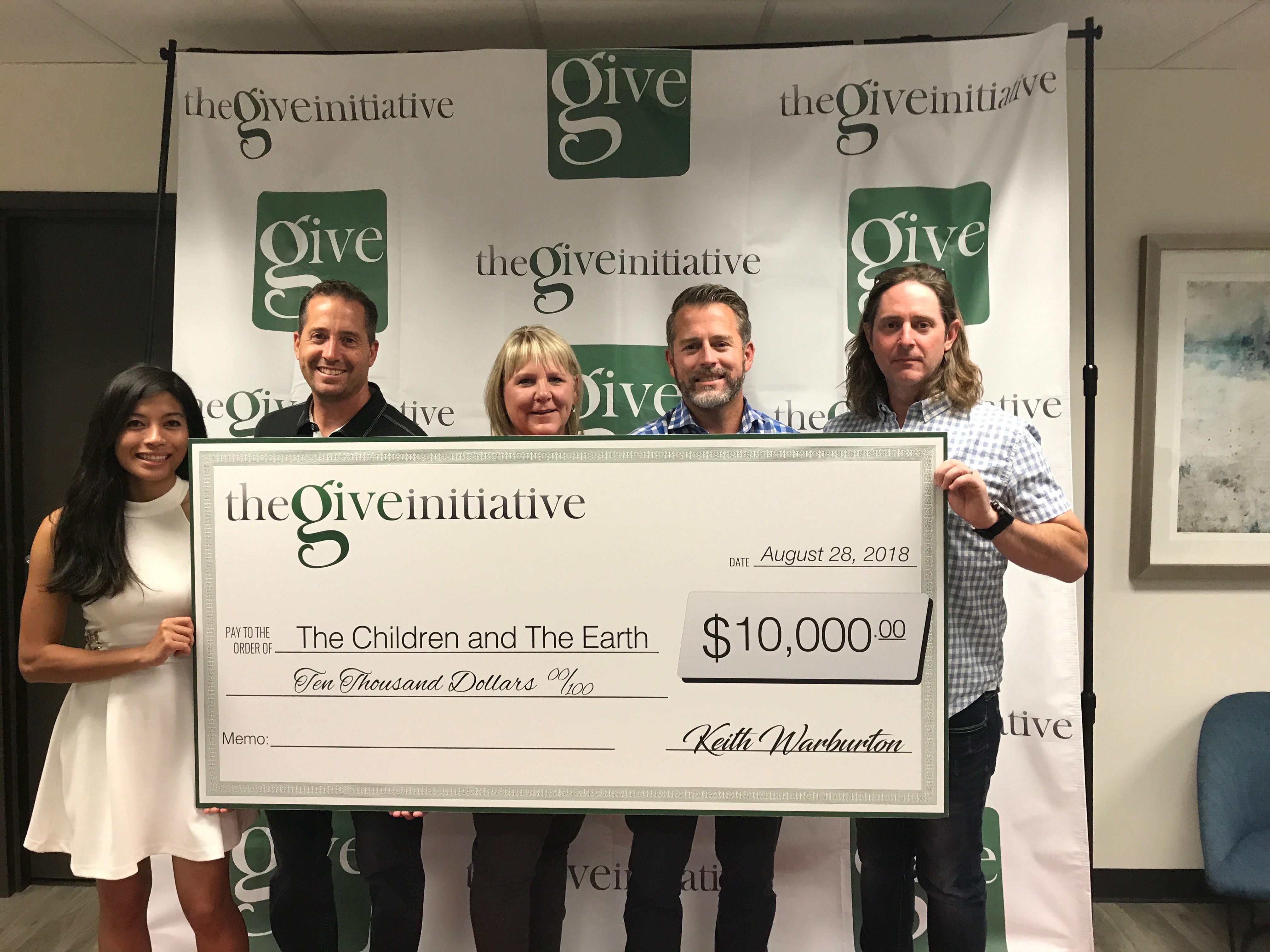 The Give Initiative presenting check of $10,000 to The Children and The Earth